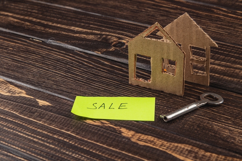 Cardboard,House,Model,Sits,Next,To,A,Bright,Yellow,Sale