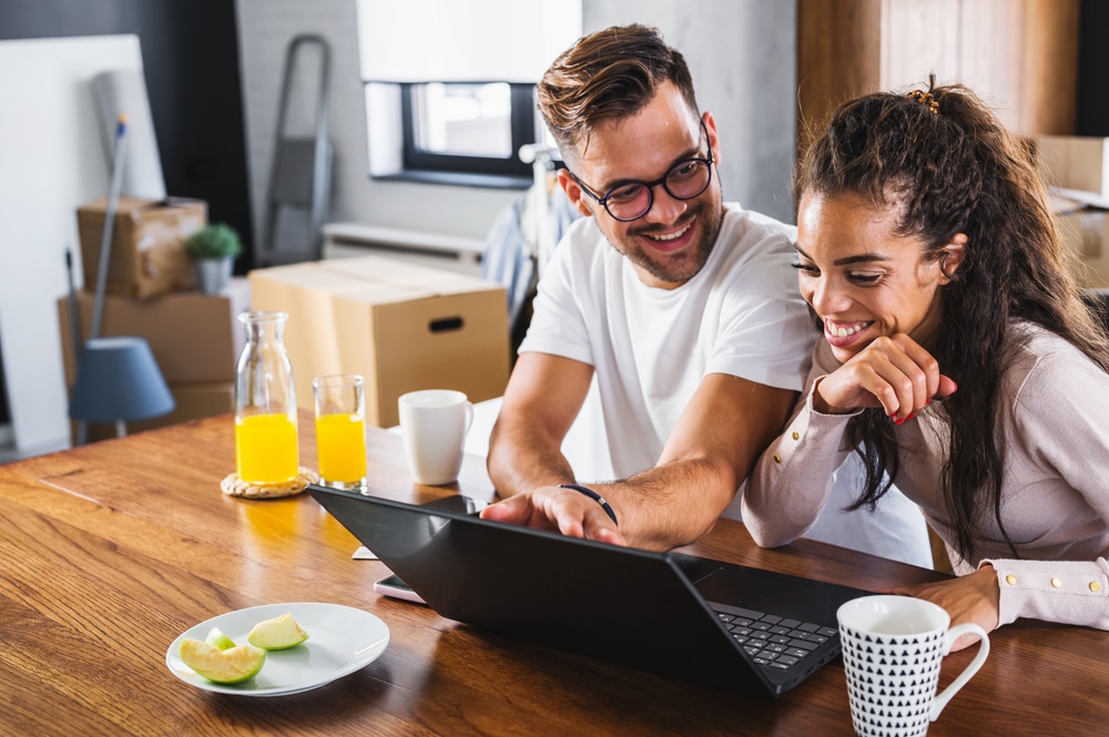Beautiful,Couple,Using,Laptop,Computer,At,Home,Surfing,The,Internet