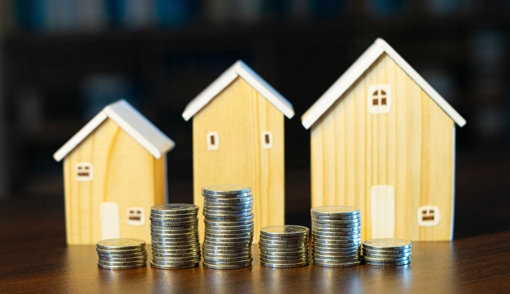 Wooden,House,And,Stacked,Coins,,Investment,Concept,For,Buying,And